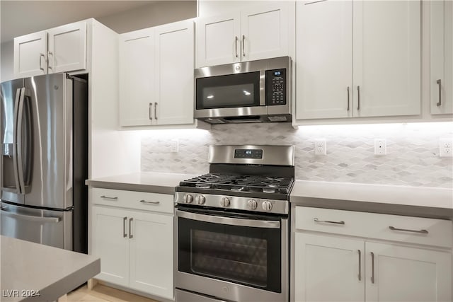 kitchen featuring white cabinets, appliances with stainless steel finishes, and tasteful backsplash