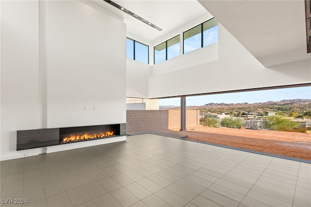 interior space featuring a towering ceiling, a mountain view, and tile patterned floors