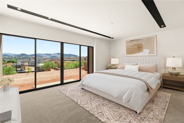 carpeted bedroom with a mountain view and access to outside