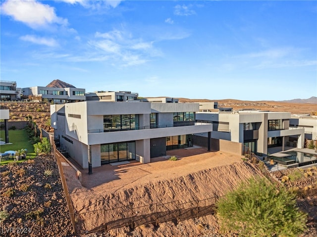 rear view of property featuring a mountain view and a balcony