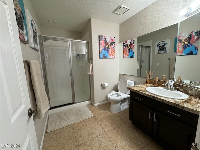 bathroom featuring vanity, toilet, a shower with shower door, and tile patterned flooring