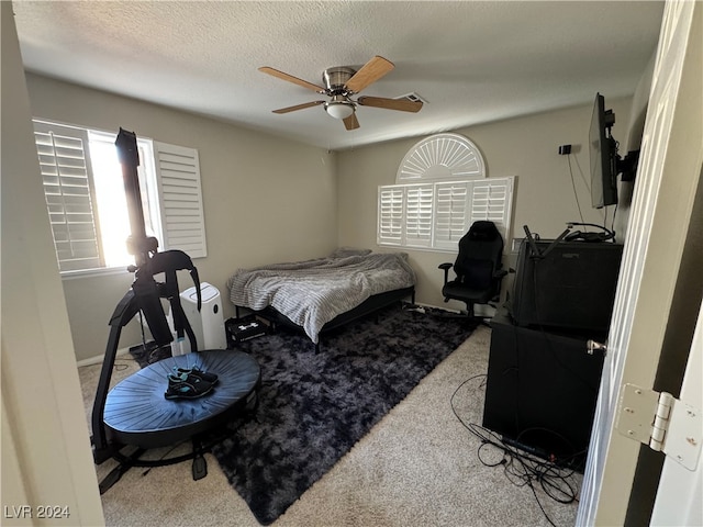 carpeted bedroom featuring a textured ceiling and ceiling fan