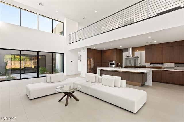 living room featuring a towering ceiling and sink