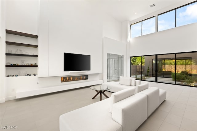 living room featuring light tile patterned flooring and a high ceiling