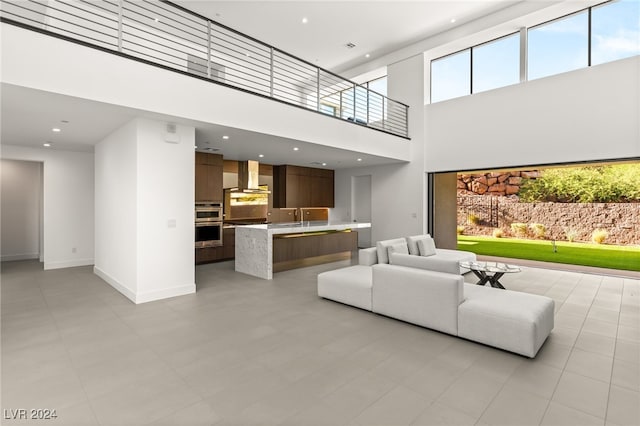 living room featuring a towering ceiling and sink