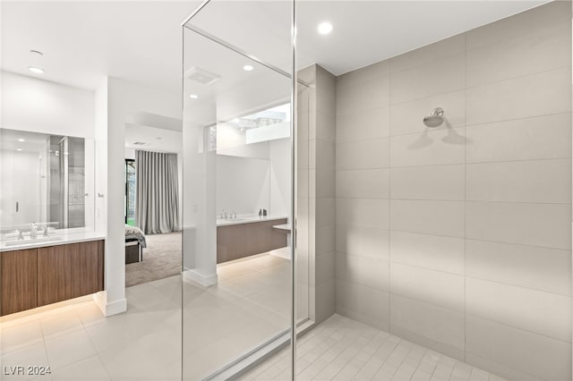 bathroom featuring vanity, a tile shower, and tile patterned flooring