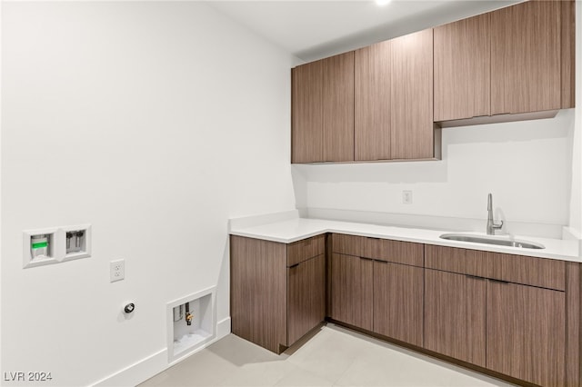 laundry area featuring cabinets, light tile patterned flooring, sink, and washer hookup