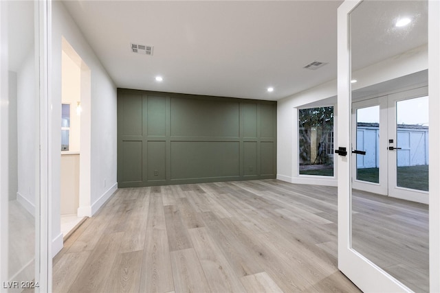 unfurnished room with french doors and light wood-type flooring