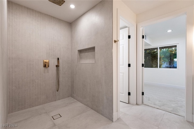 bathroom with tile patterned flooring and tiled shower