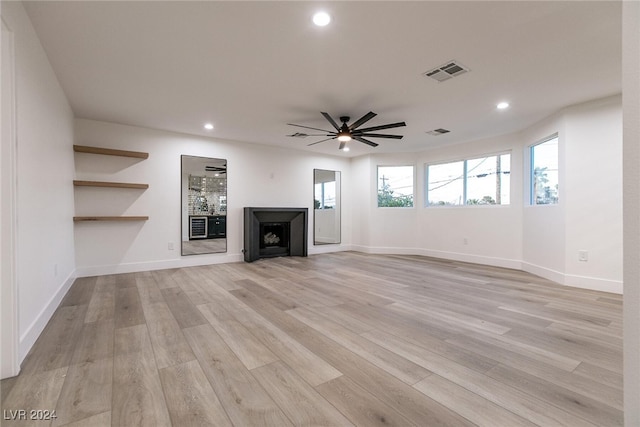 unfurnished living room with ceiling fan and light wood-type flooring