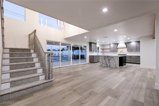 unfurnished living room featuring light hardwood / wood-style floors and a high ceiling