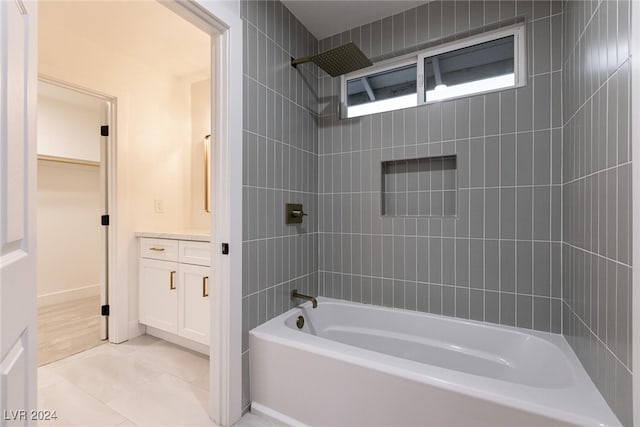 bathroom featuring vanity, tiled shower / bath combo, and tile patterned flooring