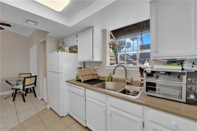 kitchen featuring white appliances, sink, light tile patterned floors, and white cabinets