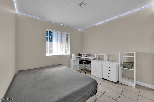 bedroom featuring a textured ceiling and light tile patterned floors