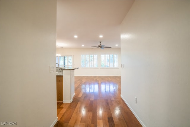 hall featuring wood-type flooring and a notable chandelier