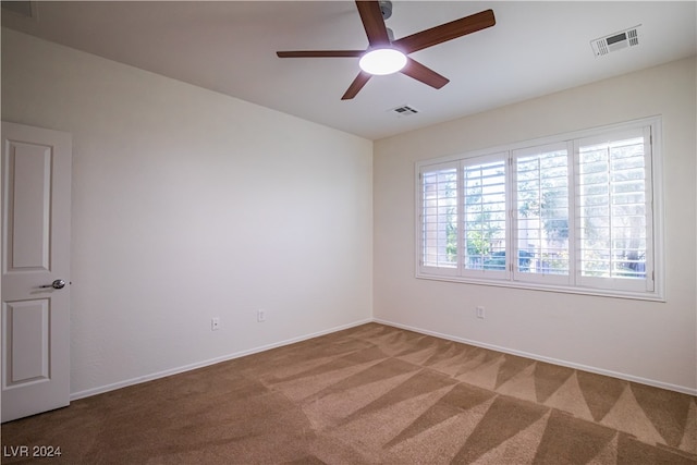 carpeted spare room with ceiling fan