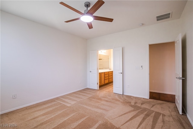 unfurnished bedroom with light carpet, ceiling fan, and ensuite bathroom