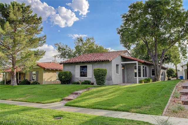 mediterranean / spanish home with a front lawn