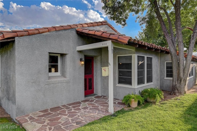 entrance to property with a lawn