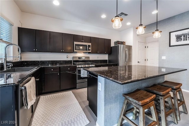 kitchen featuring a center island, stainless steel appliances, hanging light fixtures, and sink