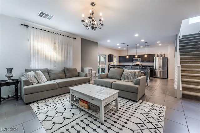 tiled living room with a notable chandelier