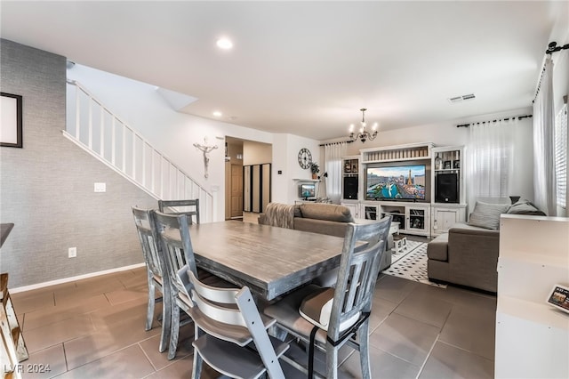 dining area featuring an inviting chandelier and dark tile patterned floors