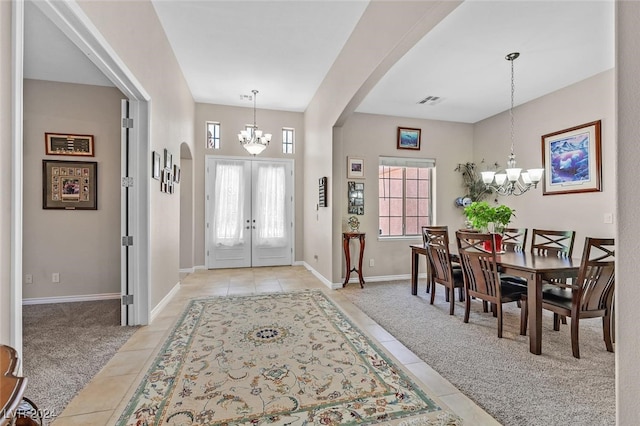 carpeted foyer entrance featuring french doors and a chandelier