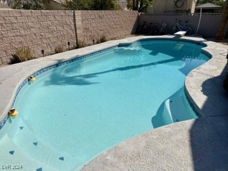 view of pool featuring a diving board