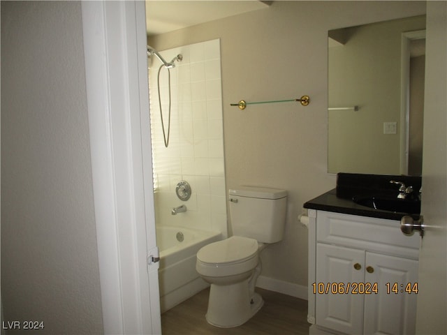 full bathroom featuring hardwood / wood-style floors, vanity, tiled shower / bath combo, and toilet