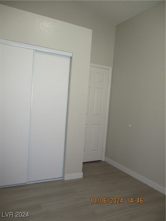 unfurnished bedroom featuring hardwood / wood-style flooring and a closet