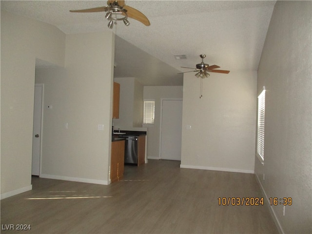 unfurnished living room with dark hardwood / wood-style floors, a textured ceiling, and vaulted ceiling