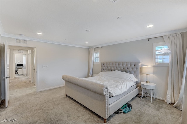 bedroom with ornamental molding and light carpet