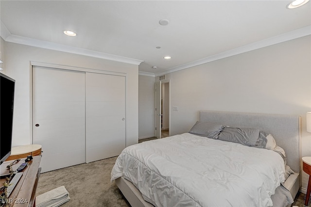 bedroom with carpet, crown molding, and a closet