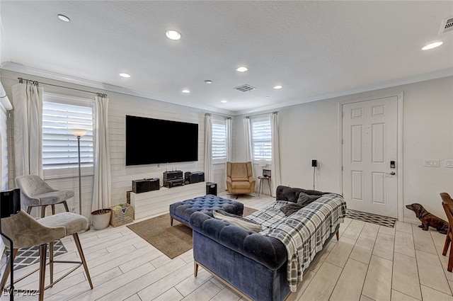 living room featuring crown molding and light hardwood / wood-style flooring