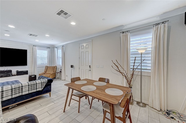 dining area featuring ornamental molding and light hardwood / wood-style floors