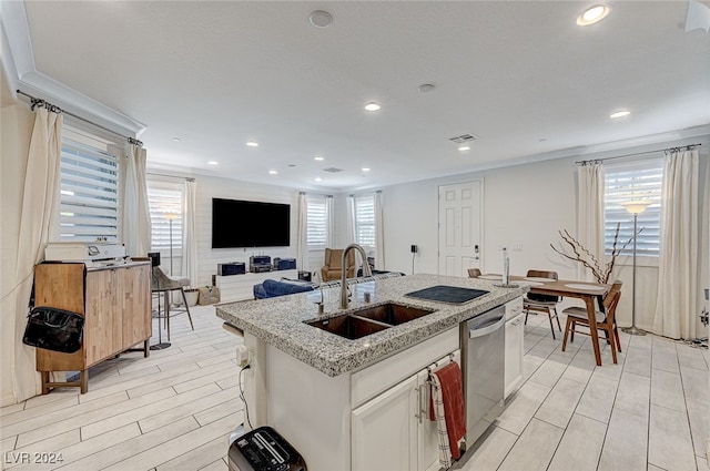 kitchen featuring a wealth of natural light, white cabinetry, a kitchen island with sink, and sink