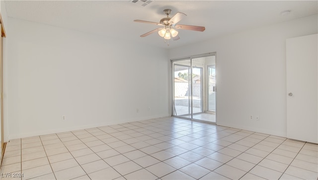 empty room with ceiling fan and light tile patterned floors