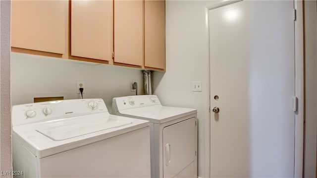 washroom with cabinets and washing machine and clothes dryer