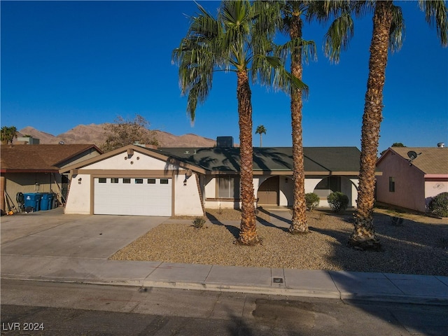 single story home featuring a mountain view and a garage