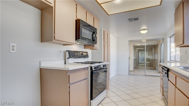 kitchen featuring cream cabinets, light tile patterned floors, and black appliances