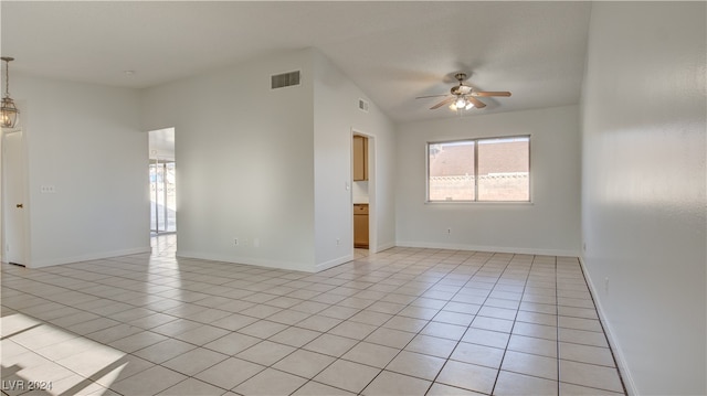 tiled empty room featuring lofted ceiling and ceiling fan