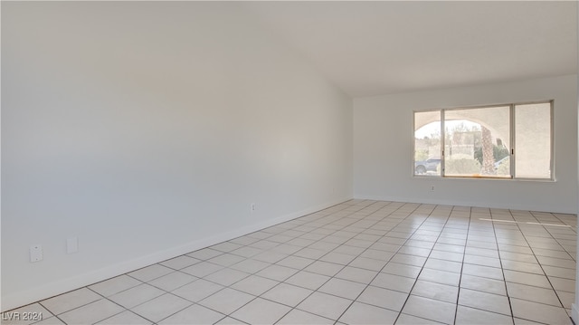 tiled spare room with lofted ceiling