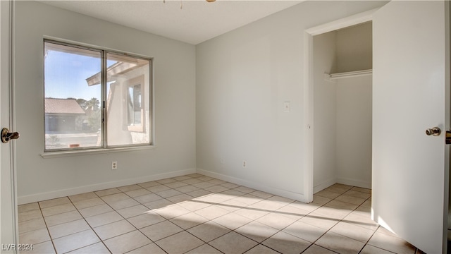 unfurnished bedroom with light tile patterned flooring and a closet