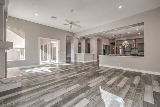 unfurnished living room featuring hardwood / wood-style flooring and ceiling fan