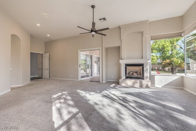 unfurnished living room featuring ceiling fan, a fireplace, and carpet flooring