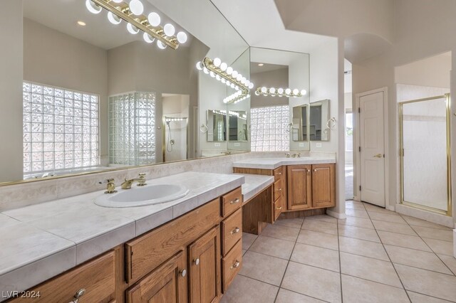 bathroom featuring tile patterned flooring, a shower with door, and vanity