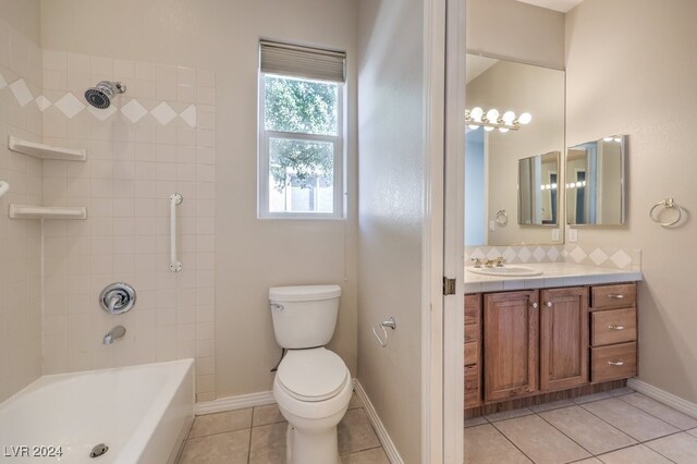 full bathroom featuring tiled shower / bath combo, vanity, tile patterned flooring, and toilet