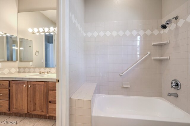 bathroom featuring tile patterned flooring, vanity, and tiled shower / bath combo