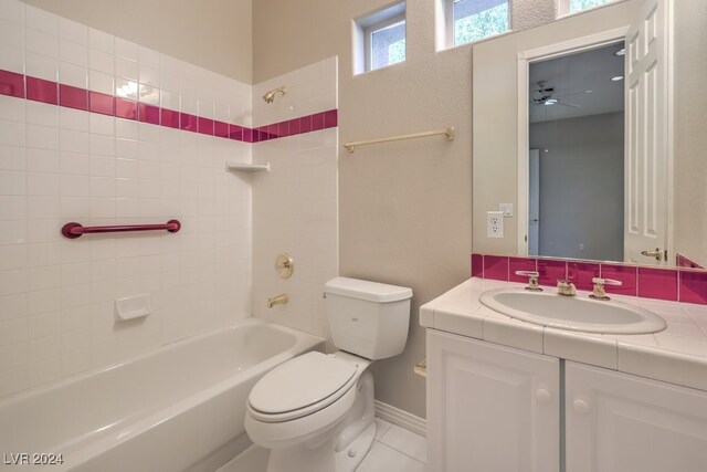 full bathroom featuring ceiling fan, toilet, tile patterned floors, tiled shower / bath, and vanity