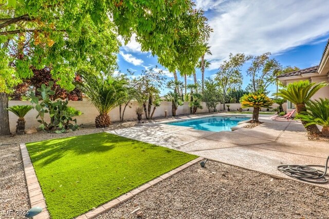 view of pool featuring a yard and a patio